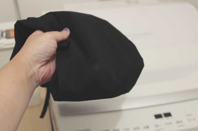 リペアパッチを貼ったウェアを洗濯機に入れるところ