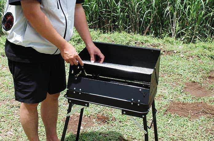 網をBBQコンロにセットする男性