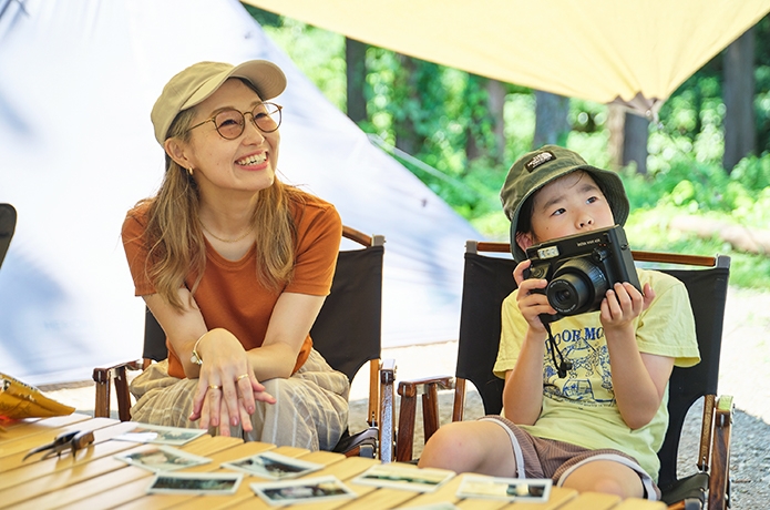 椅子に座った母親とカメラを持った子ども