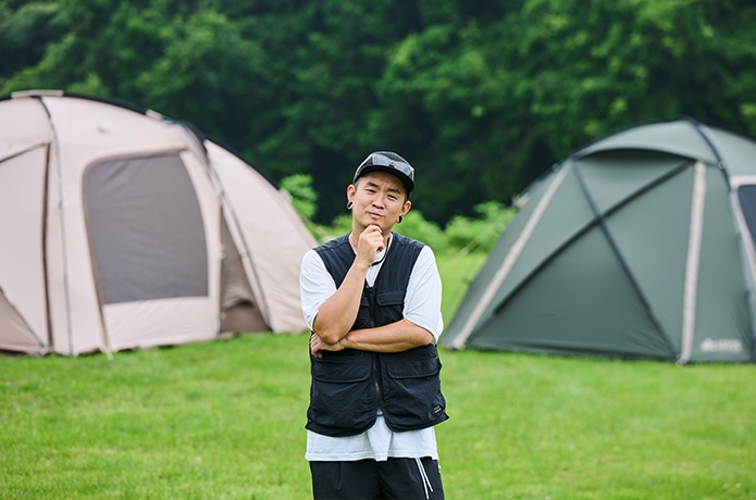 テントの間に立って考えている男性