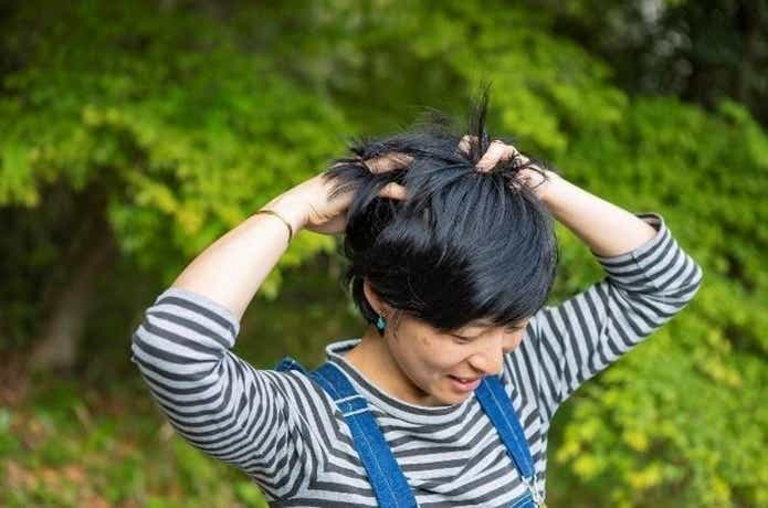 ドライシャンプーで頭皮をケアしている女性