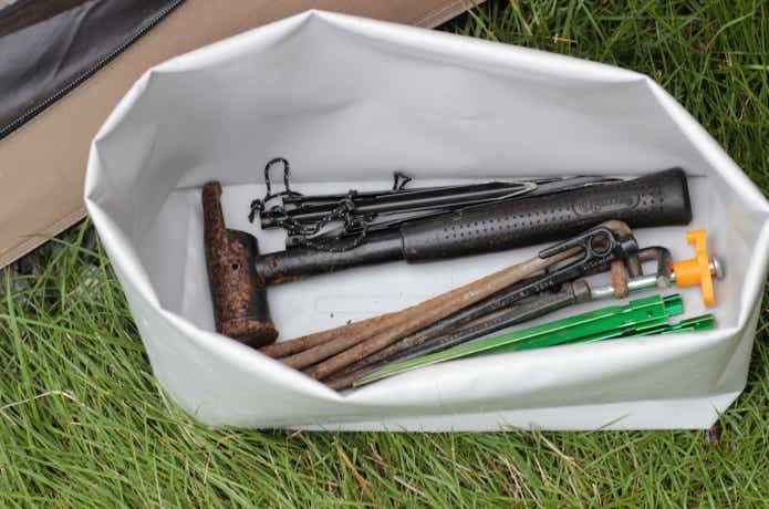 折って高さが変えられるターポリン収納ケース大に汚れたペグを入れている