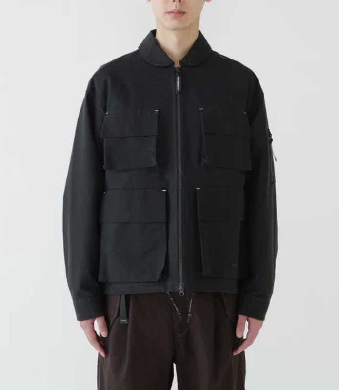 アンドワンダー「C/PE twill field jacket」を着る男性