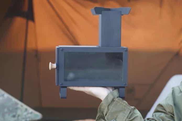 黒いミニ薪ストーブを持つ